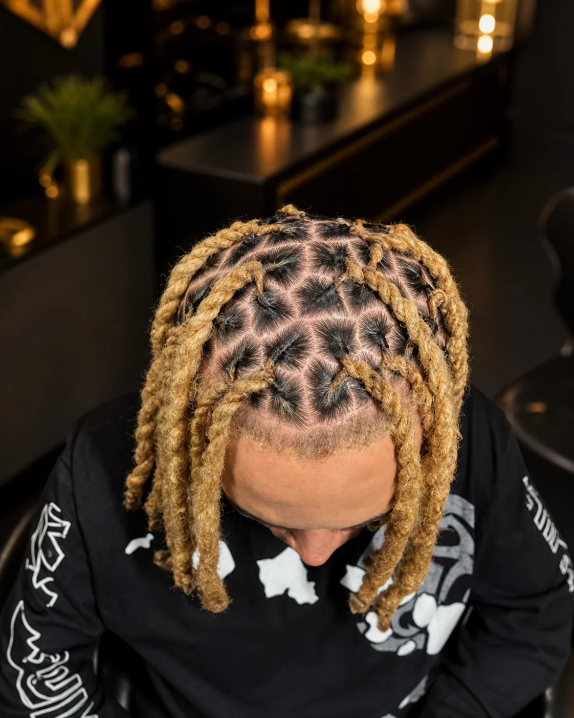 Golden locs with precise geometric parting viewed from above