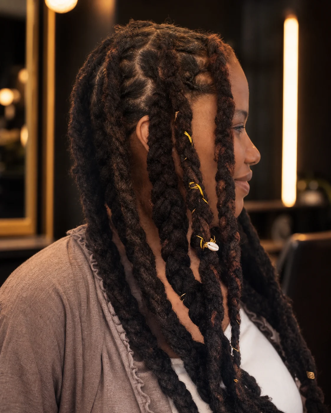 Very long locs decorated with subtle gold cord and cuffs